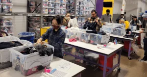 The morning team of Credico volunteers works on matching and packing chldrens' outfits at Cradles to Crayons
