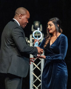 Patrick Ilunga presents an award to Davita Maistry on stage during the South Africa Awards Gala in March 2025