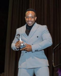 Alstair Katumba poses with his 5 Million Award on stage at the South Africa Awards Gala in March 2025