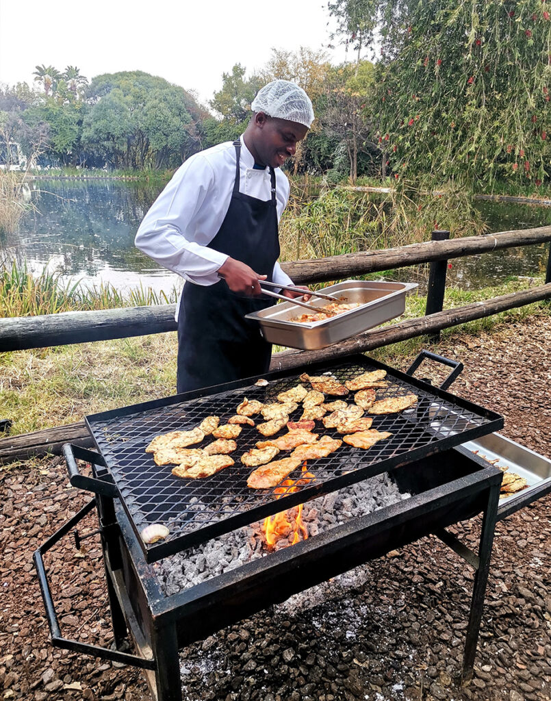 A chef grills delicious food on an outdoor grill at Credico South Africa's 2025 Christmas in July