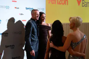 Attendees wait to pose for photographs in front of a sponsor-branded backdrop at the 2026 Limitless Kickoff Gala