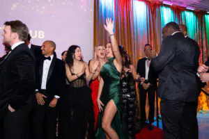 Beverly Pragosa raises her arm in joyous celebration alongside Danielle Hay and Stephanie Shang as they are welcomed to the stage during the 2026 Limitless Kickoff Gala