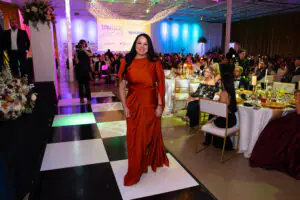 Blanca Valdez strides confidently across the black-and-white tiled floor in front of the stage as she approaches to receive an award at the 2026 Limitless Kickoff Gala