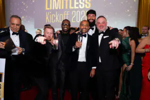 A group of high-rolling supporters surrounds Igor Barbosa for an excited group photo with his award at the 2026 Limitless Kickoff Gala