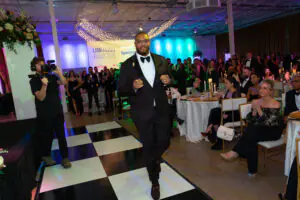 Regional Consultant Marques Aiken points confidently at the camera as he approaches the stage to accept an award at the 2026 Limitless Kickoff Gala