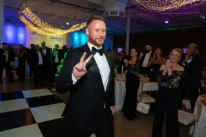 National Consultant Matthew Goodchild smiles and flashes a peace sign as he approaches the stage to give a speech at the 2026 LImitless Kickoff Gala