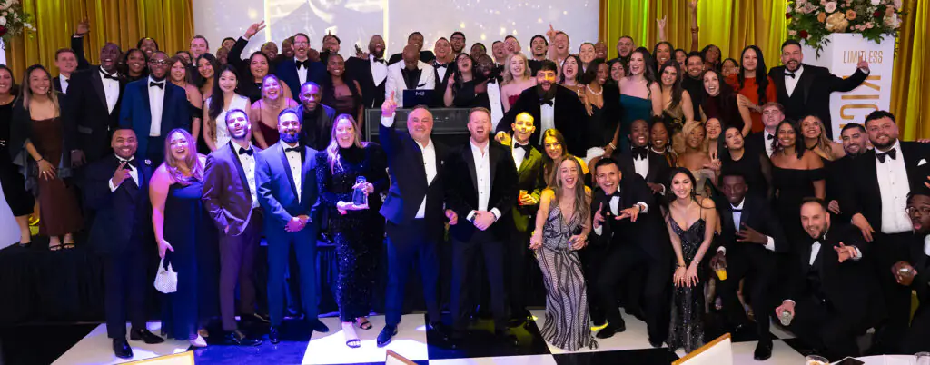 Rows and rows of awardees crowd the stage for a cheering group photo at the 2026 Limitless Kickoff Gala