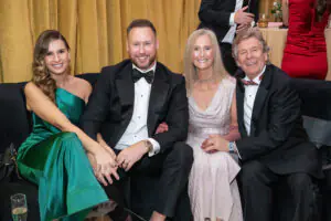 National Consultant Matthew Goodchild smiles with his fiancee and parents while seated on a gold couch at the 2026 Limitless Kickoff Gala